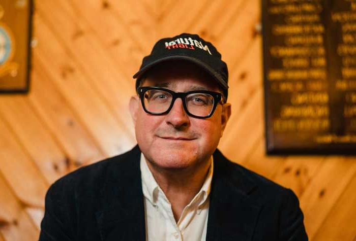 Craig Finn photographed seated on a couch.